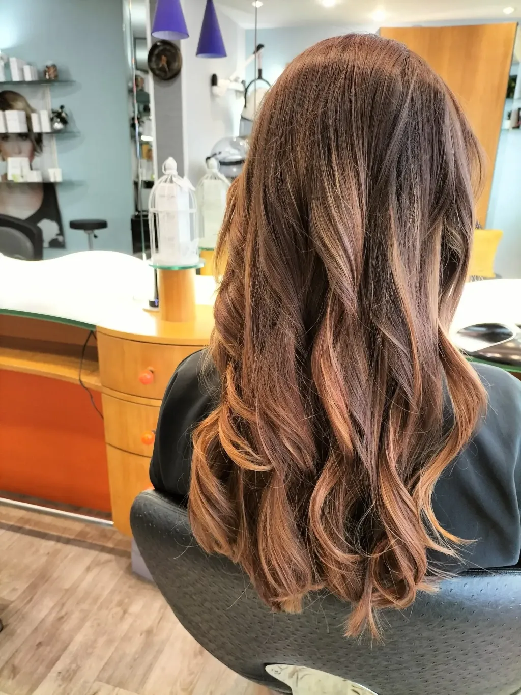 Longs cheveux bruns ondulés avec balayage caramel, réalisé au Salon de Muriel à Bordeaux