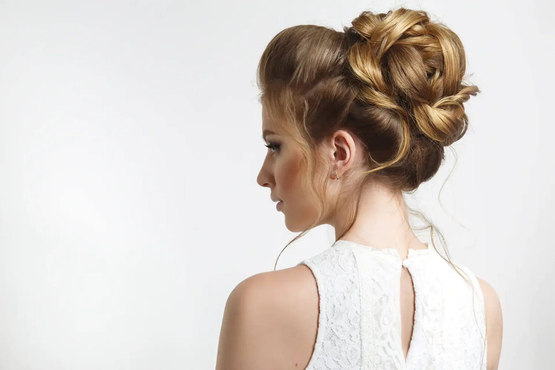 Chignon haut tressé aux reflets dorés pour occasion spéciale, réalisé au Salon de Muriel à Bordeaux