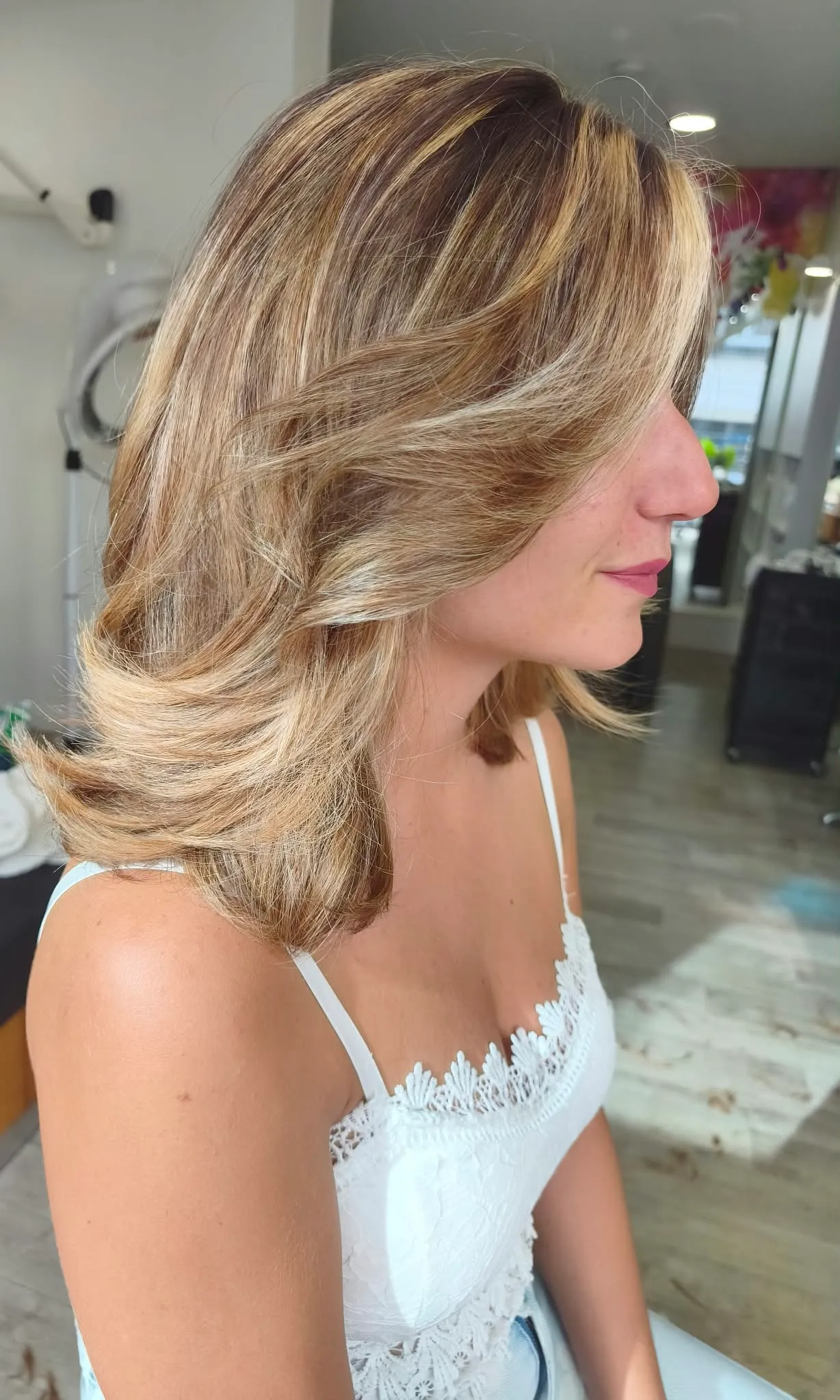 Vue de profil droit d’un ombré blond très clair beige sur une coupe mi-longue souple