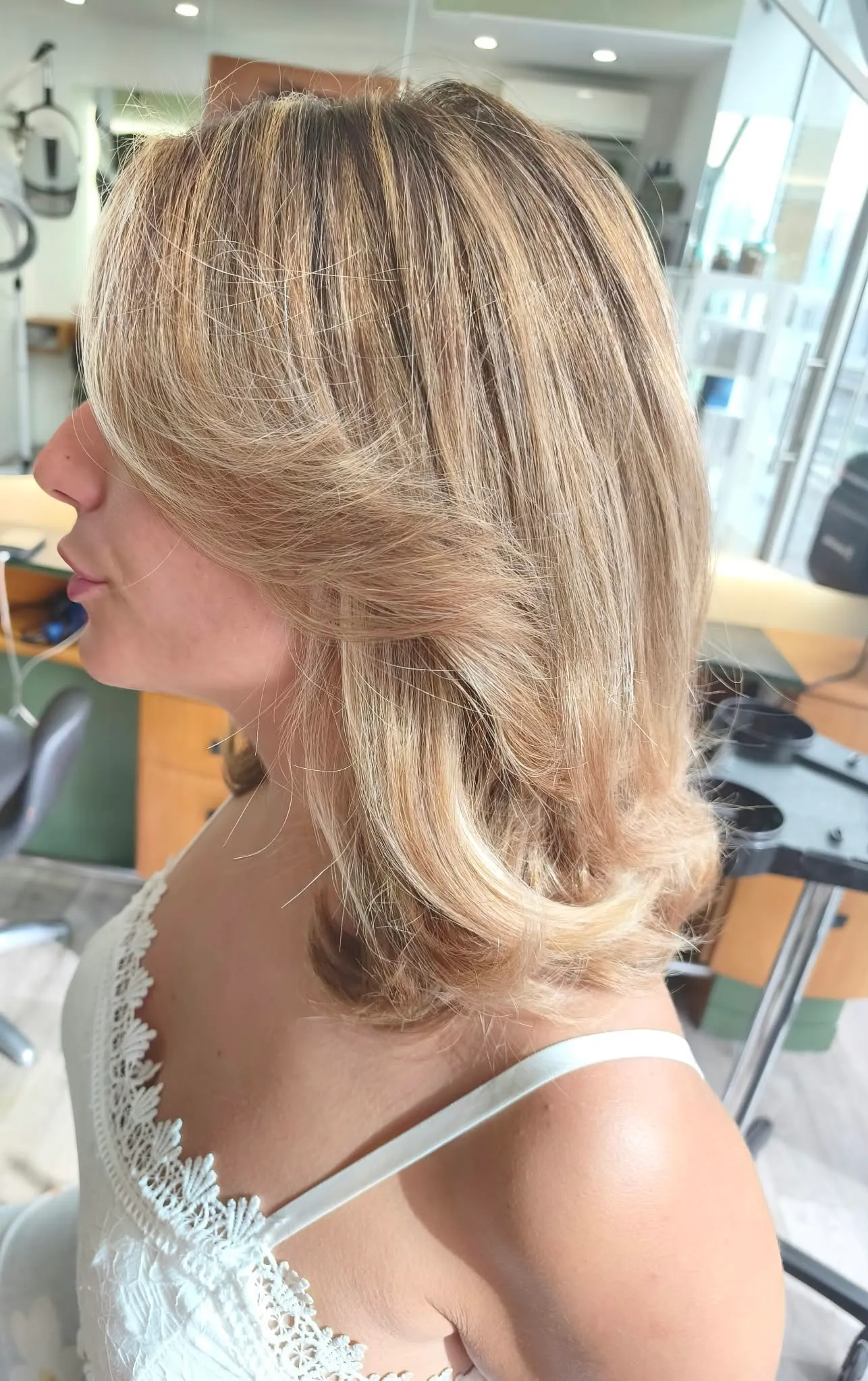 Vue de profil gauche d’un ombré blond très clair beige avec des mèches lumineuses autour du visage