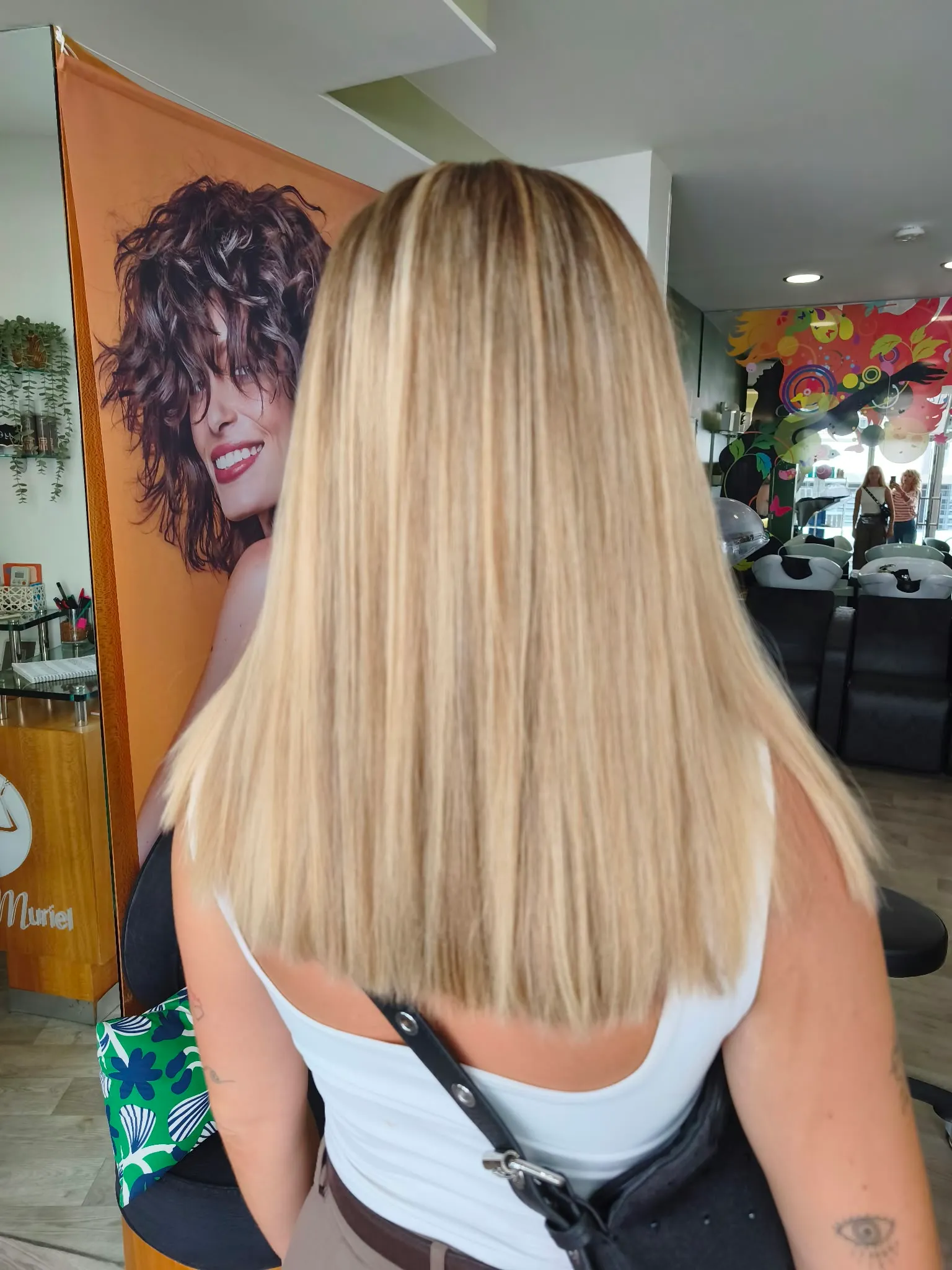 Vue de dos d’un ombré blond très clair sur des cheveux longs à la coupe droite