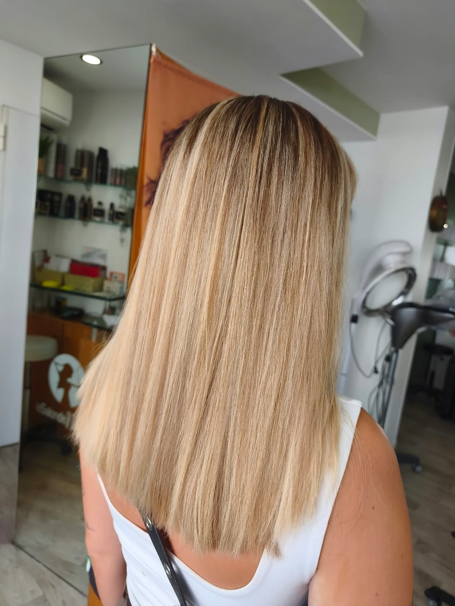 Cheveux longs et lisses avec des racines fondues dans un ombré blond très clair