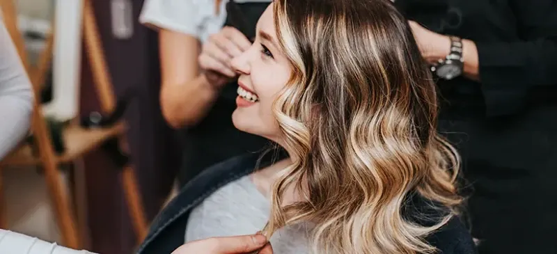 Cliente souriante avec balayage blond miel lors d'un relooking au Salon de Muriel à Bordeaux